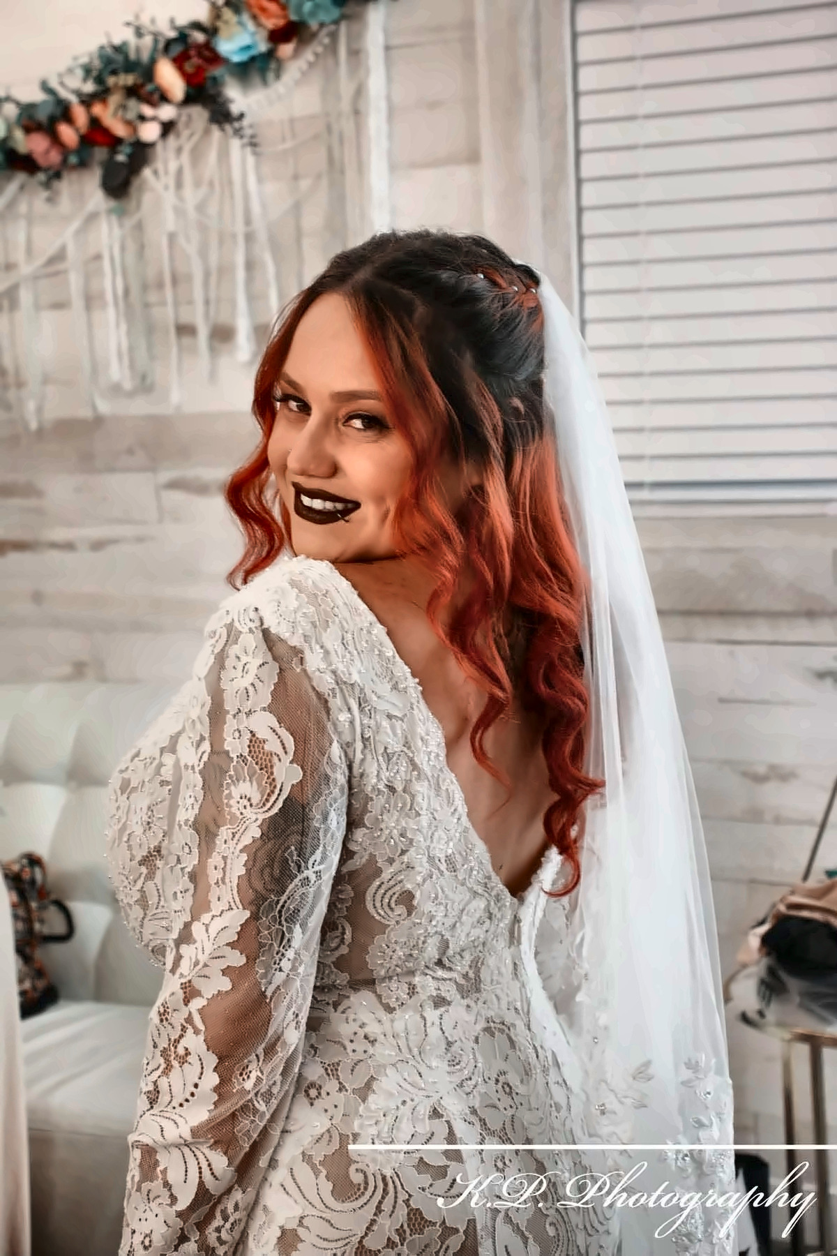 Bride in a lace gown smiling over her shoulder