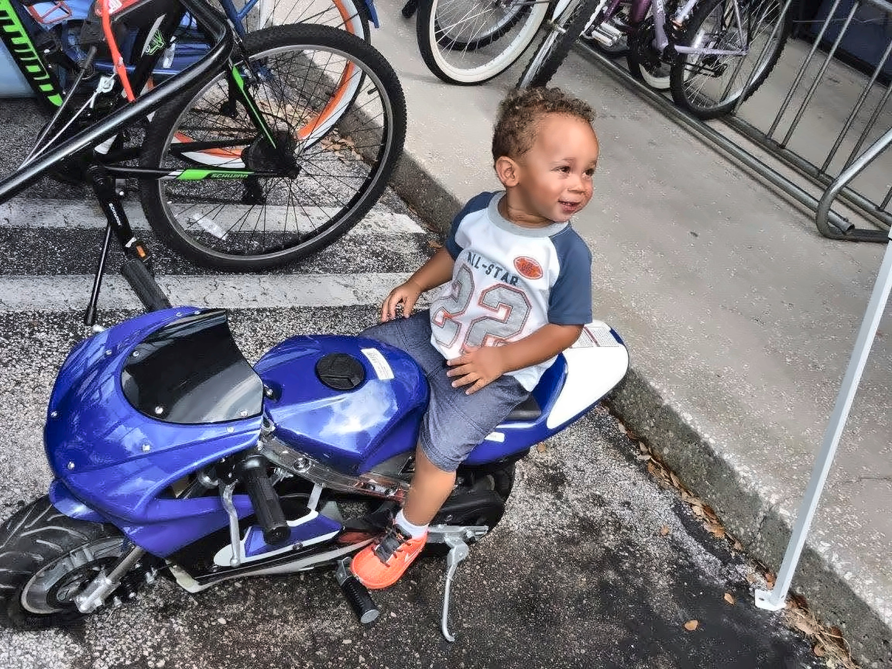 Toddler sitting on a small blue motorcycle