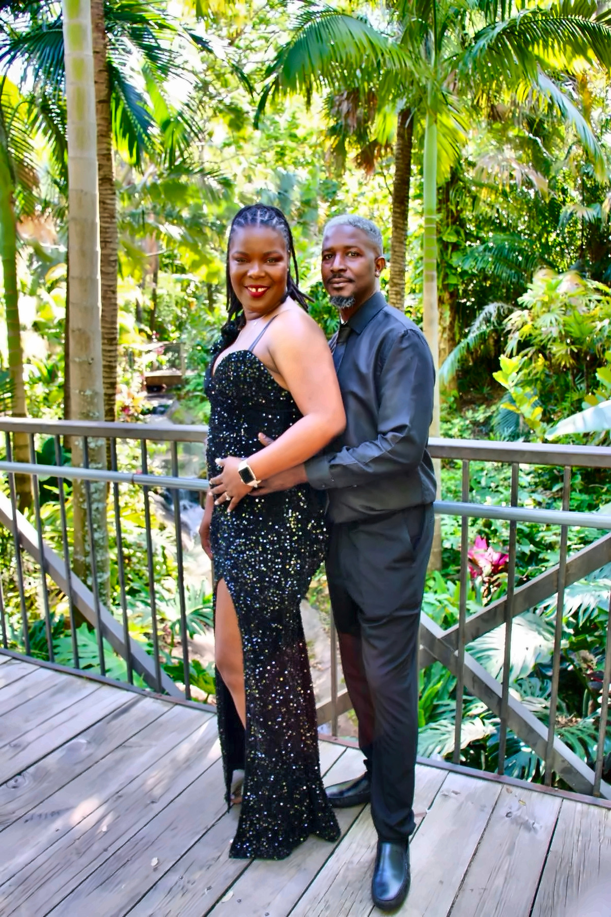 Couple dressed in black posing in a tropical garden